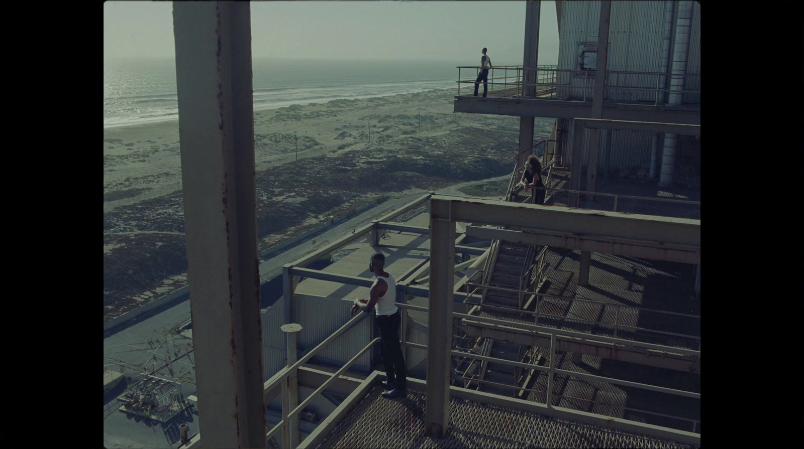 a man standing on top of a building next to the ocean