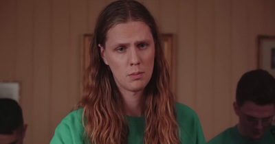 a man with long hair and a green shirt