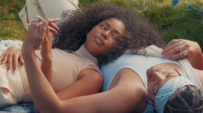 a woman laying on top of a grass covered field