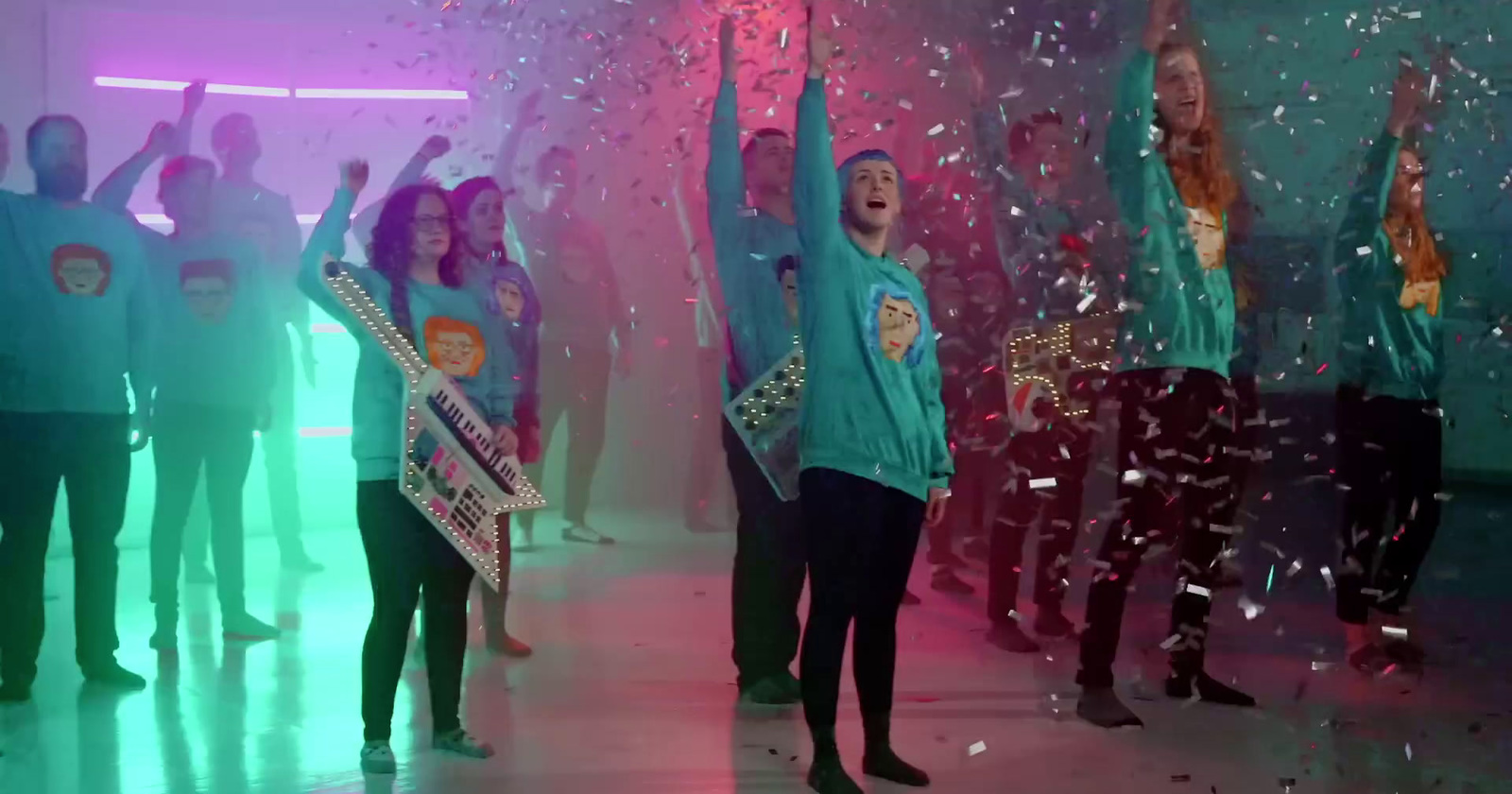 a group of people standing in a room with confetti