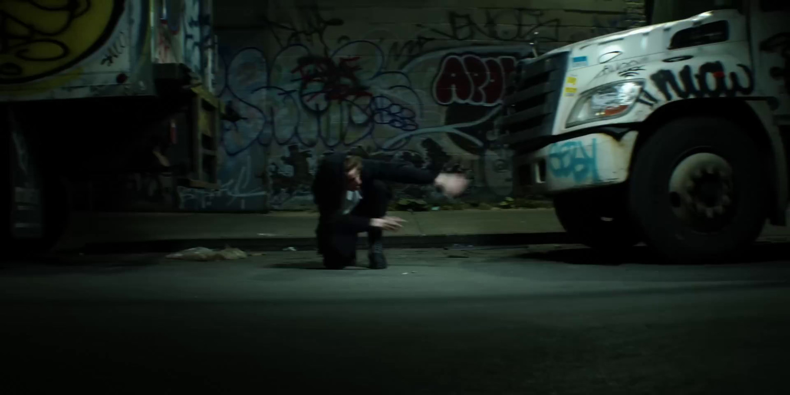 a man kneeling down in front of a truck