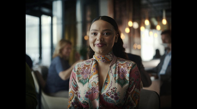 a woman standing in a room with other people