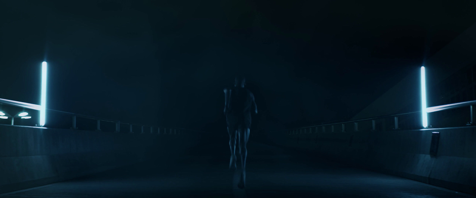 a man standing alone in a dark tunnel