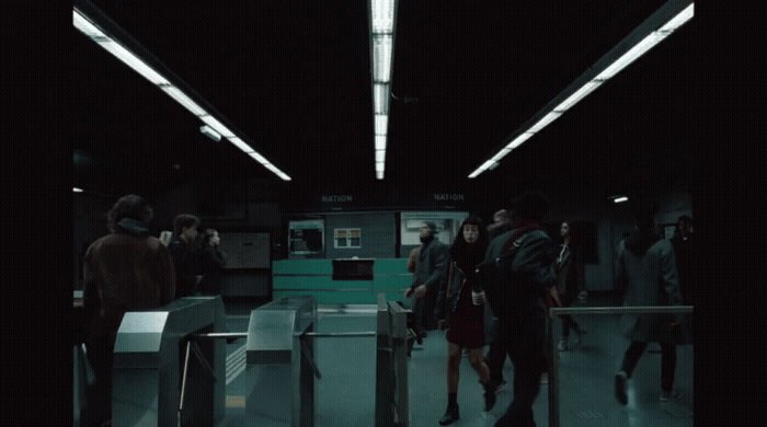 a group of people walking through a train station