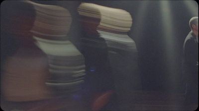 a blurry photo of a man standing in front of stacks of books