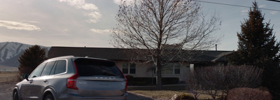 a silver car parked in front of a house