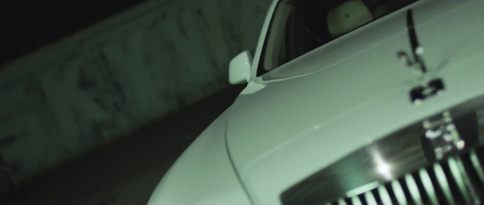 a white car parked in a parking lot at night