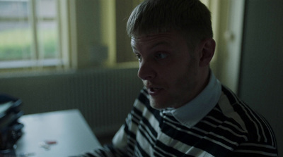 a man in striped shirt sitting at a table