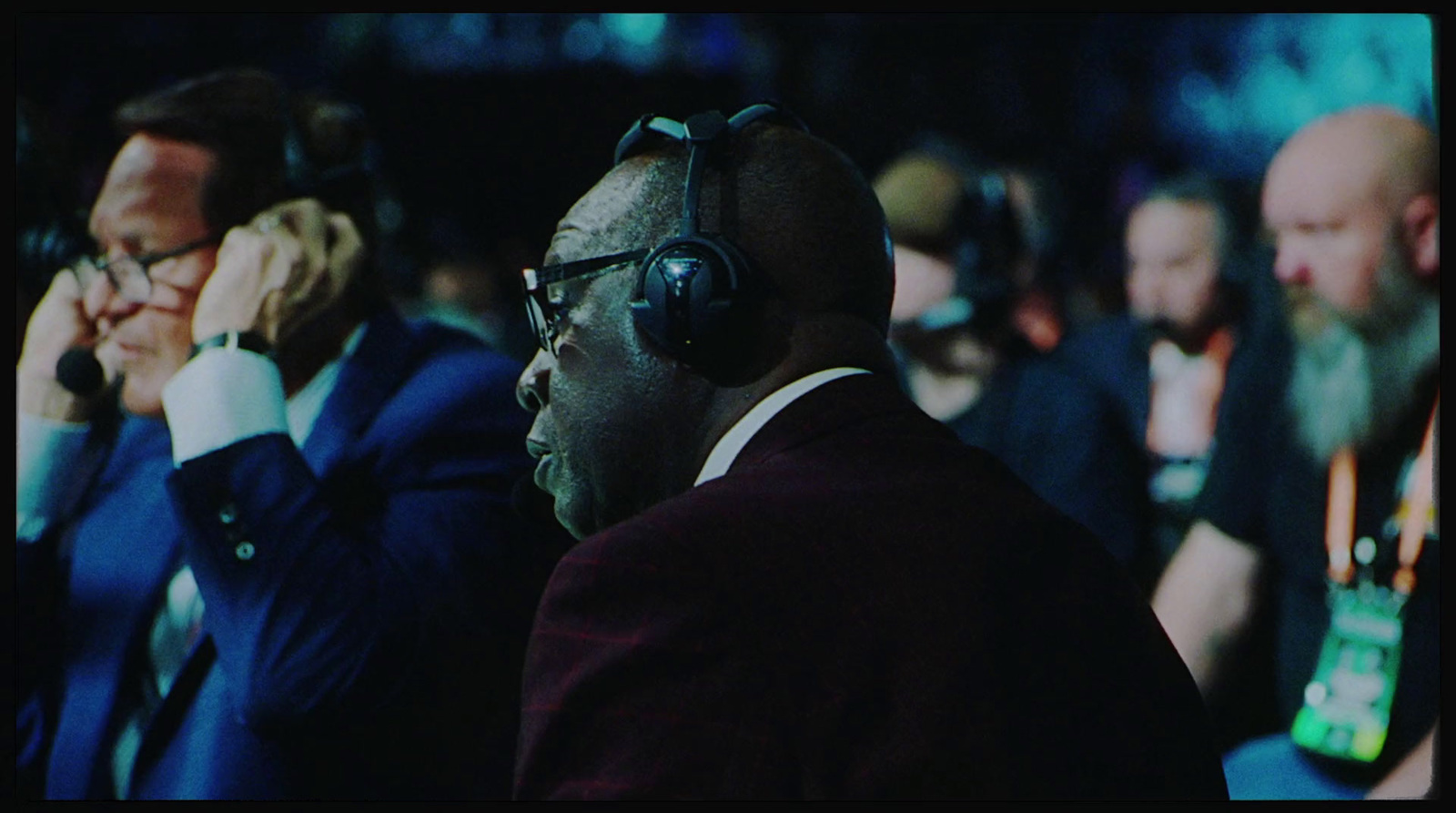 a group of men sitting next to each other wearing headphones