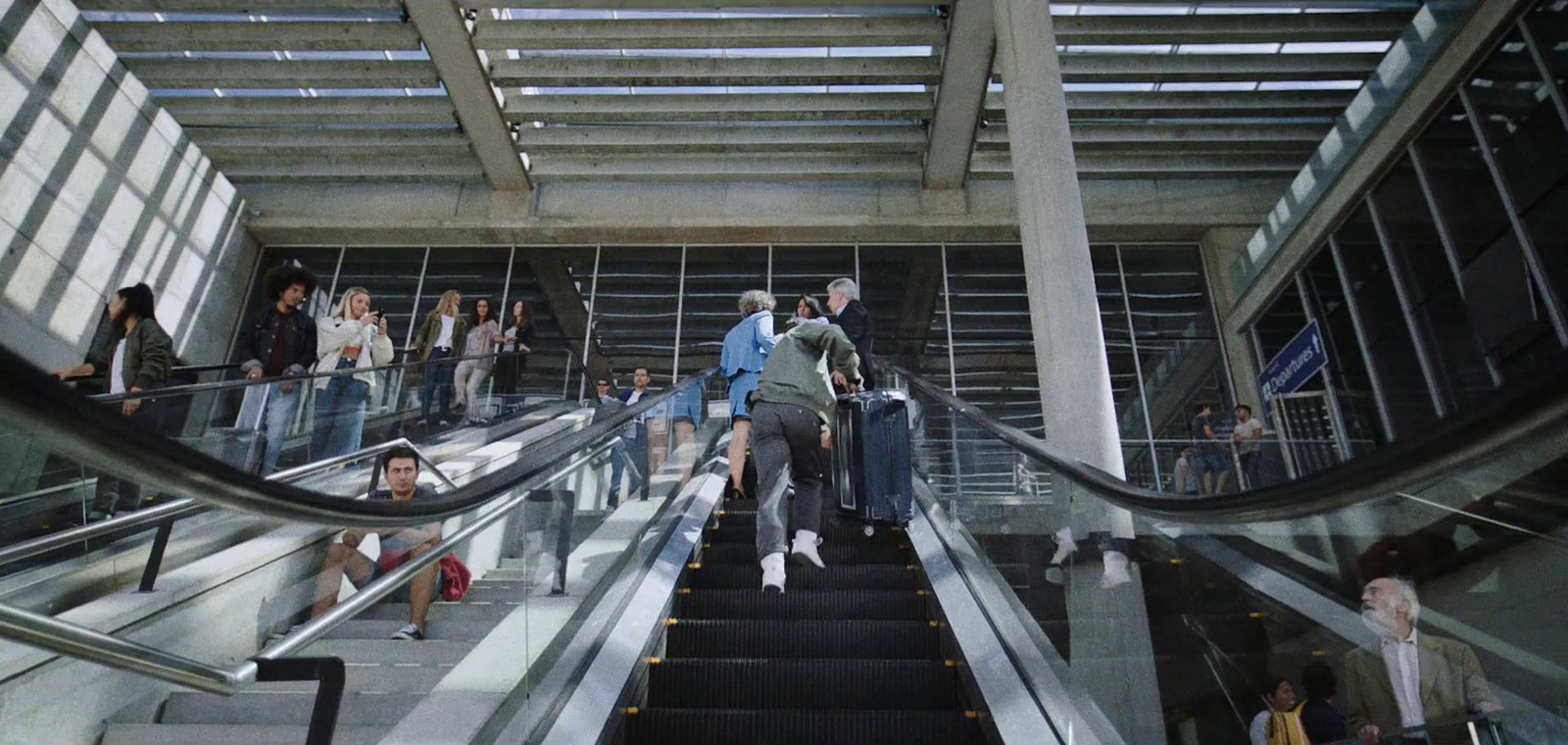 a group of people riding down an escalator