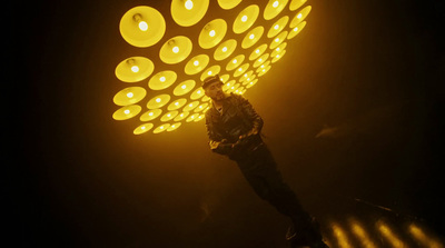 a person standing under a yellow light in the dark