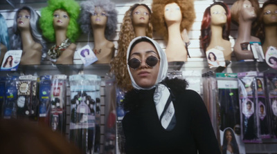 a woman wearing sunglasses and a hoodie in a store