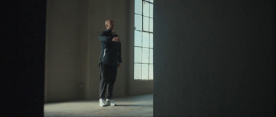 a man standing in an empty room with his arms crossed