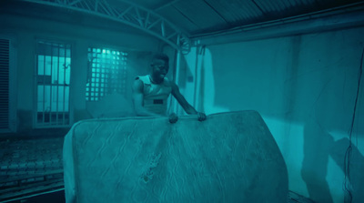 a man sitting on top of a mattress in a room