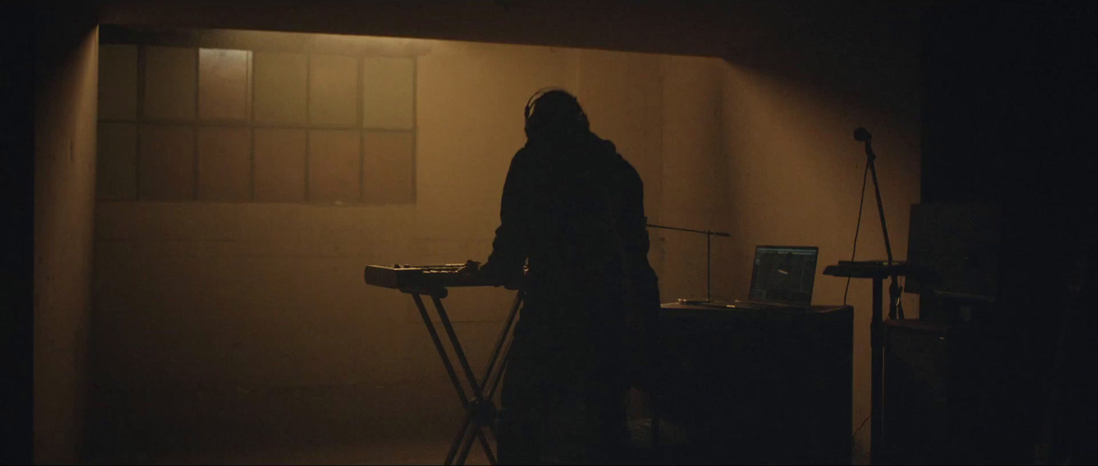 a person standing in a dark room with a laptop