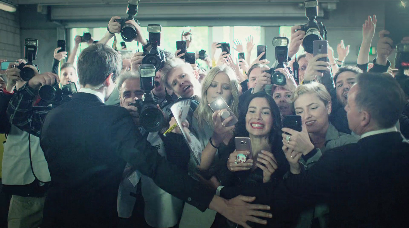 a group of people taking pictures with their cell phones