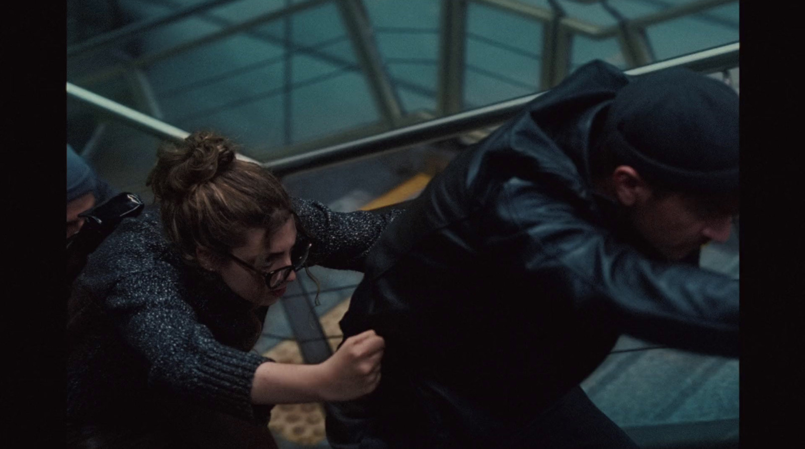 a man helping a woman down an escalator