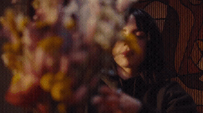 a woman looking at flowers in a vase