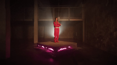 a woman standing on a platform in a dark room