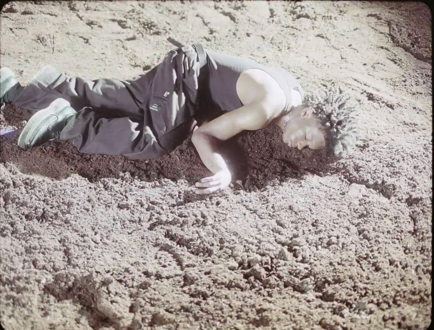 a person laying in the sand with a frisbee