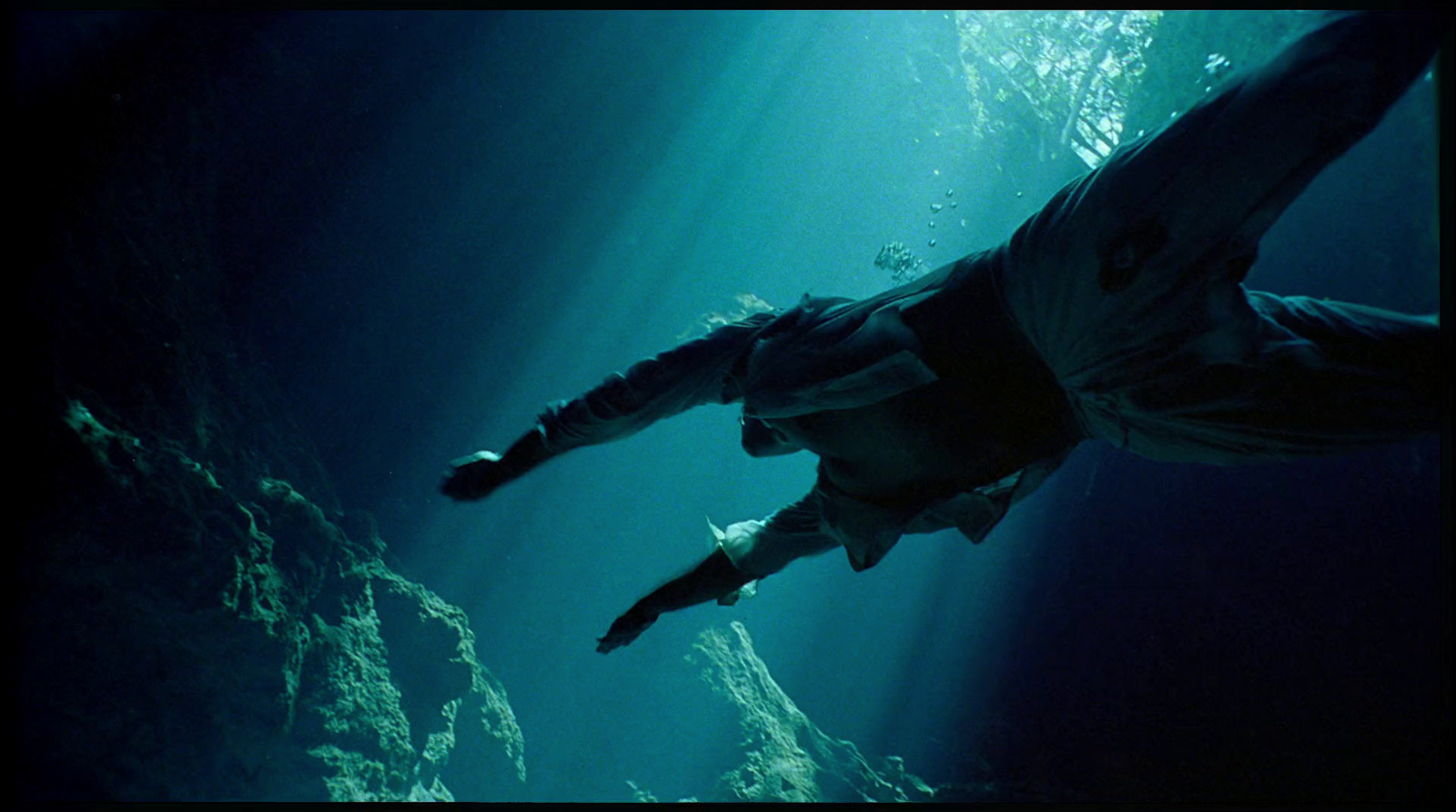 a man is swimming in the water with his back to the camera