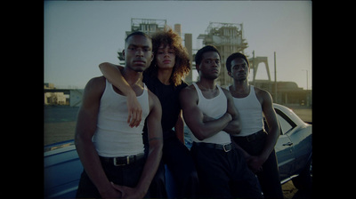 a group of men standing next to each other in front of a car