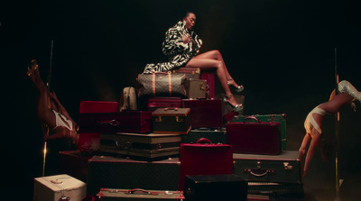 a woman sitting on top of a pile of luggage