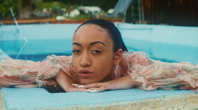 a woman in a pink dress laying in a pool