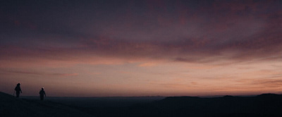 a couple of people standing on top of a hill