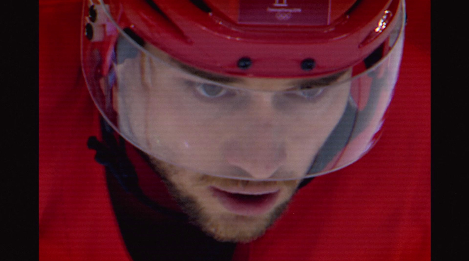 a man wearing a red helmet and looking at the camera