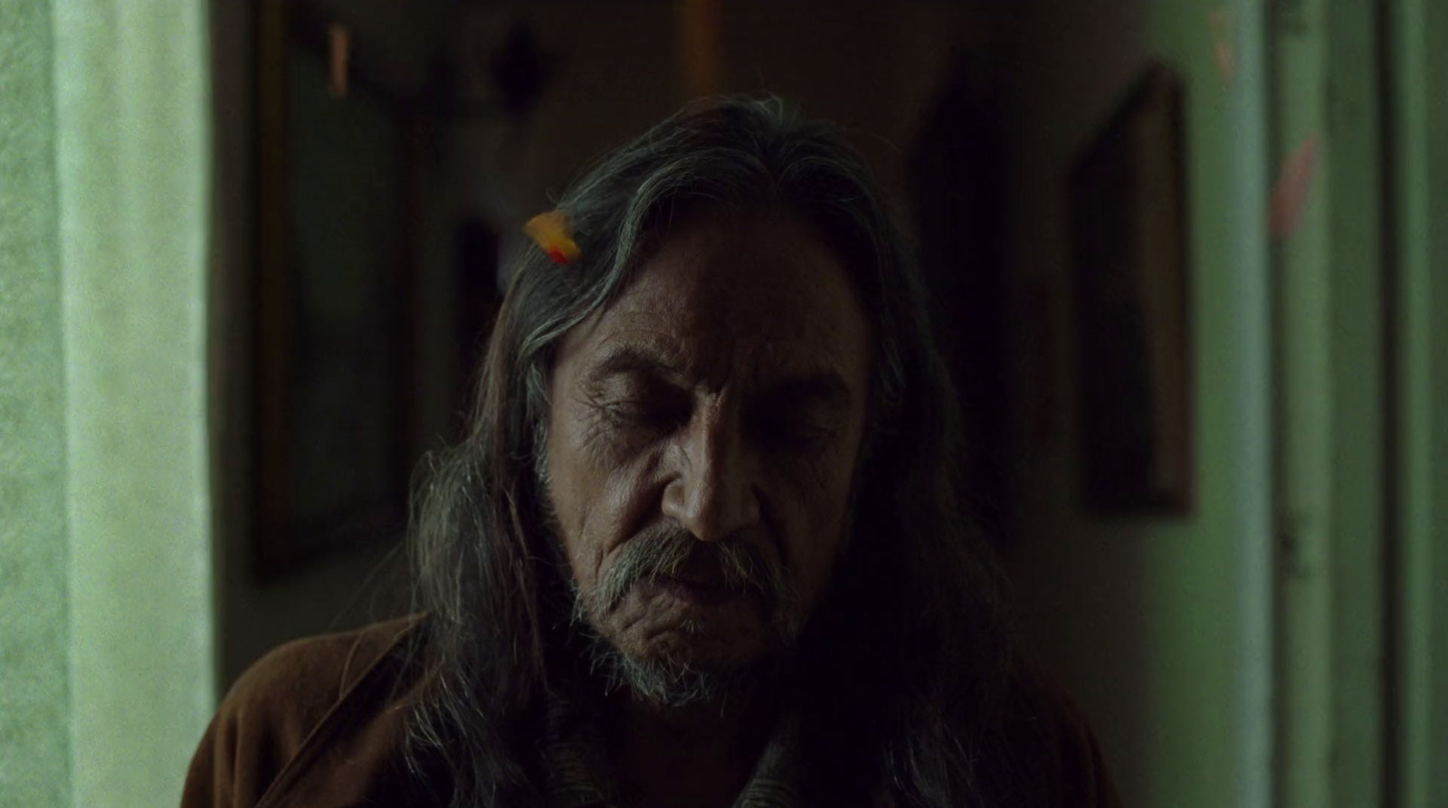 a man with long hair standing in a room