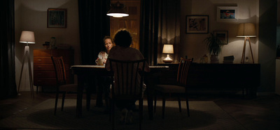 a woman sitting at a table in a dark room