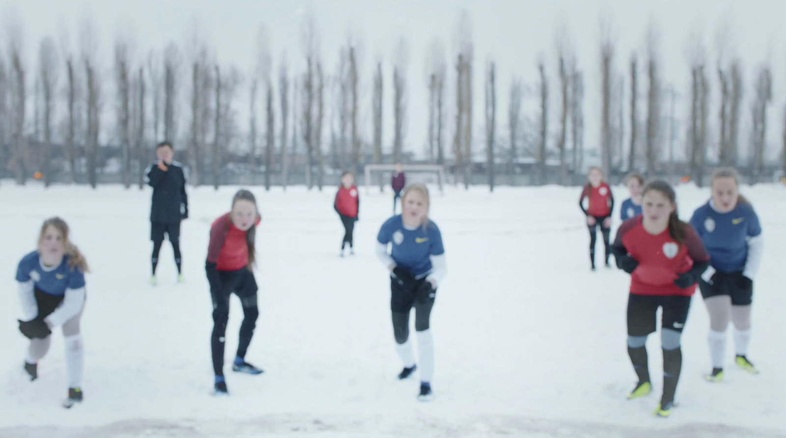 a group of people playing soccer in the snow