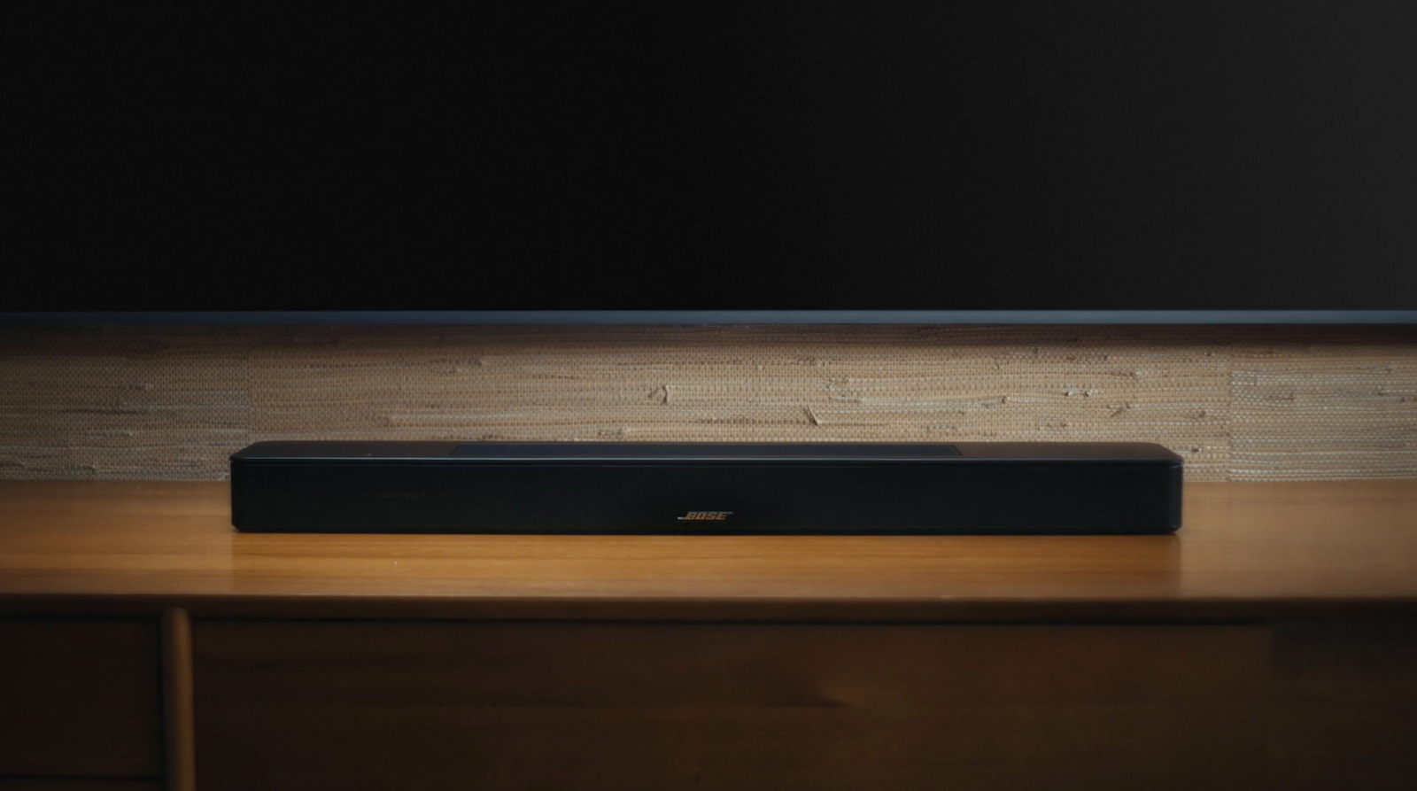 a black speaker sitting on top of a wooden desk