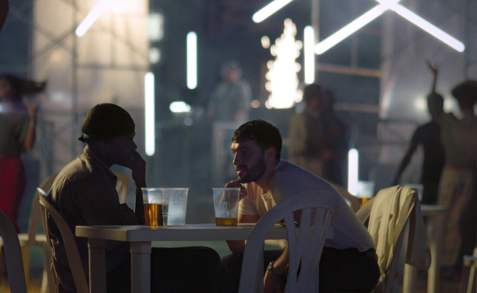 a couple of men sitting at a table next to each other