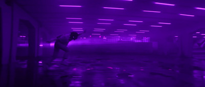 a person standing in a room with purple lights