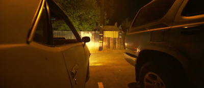 a car parked next to a fence at night