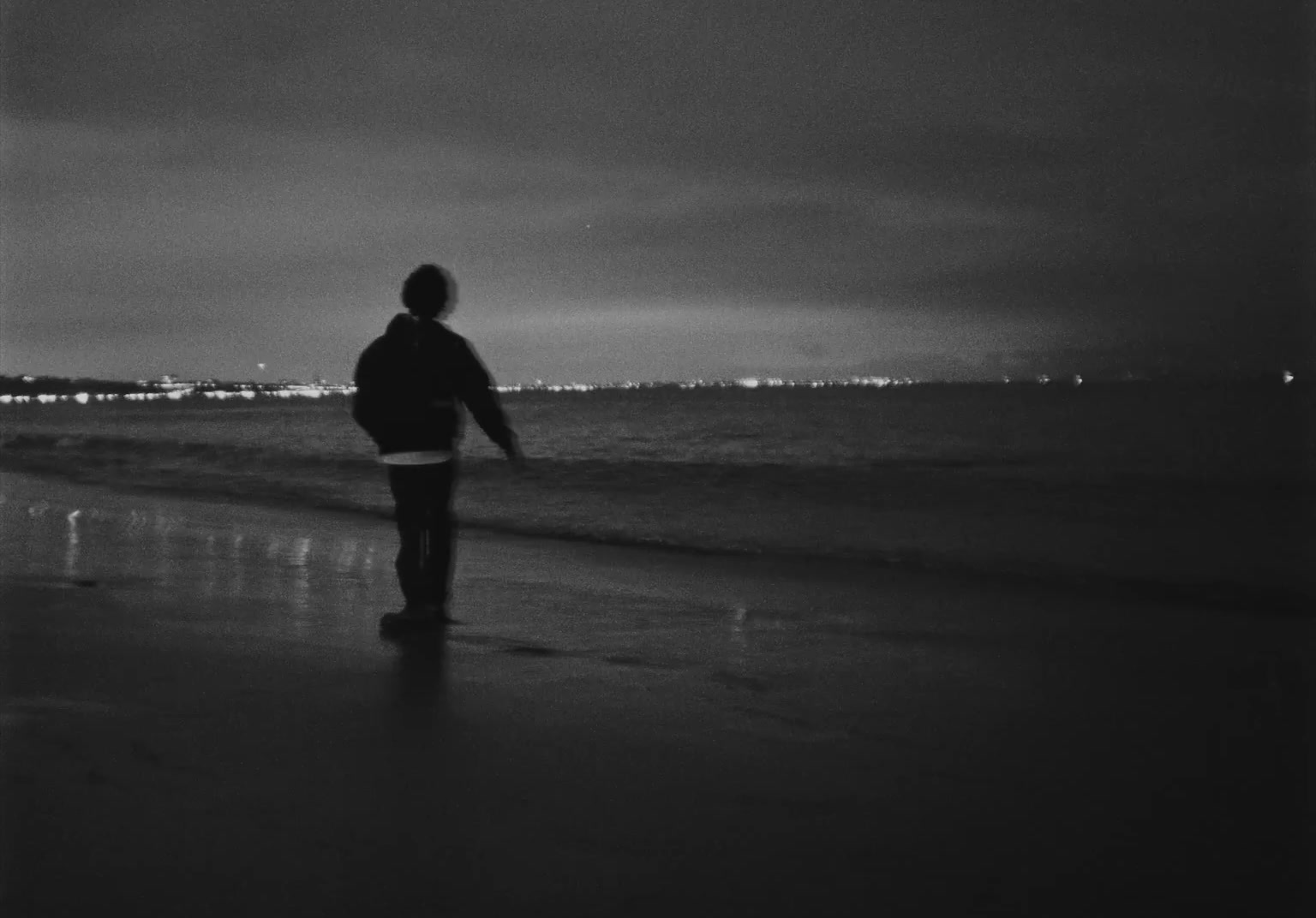 a person standing on a beach near the ocean