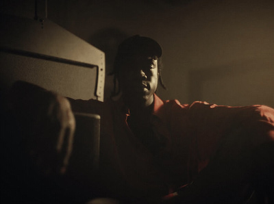 a man in a baseball cap sitting in a dark room