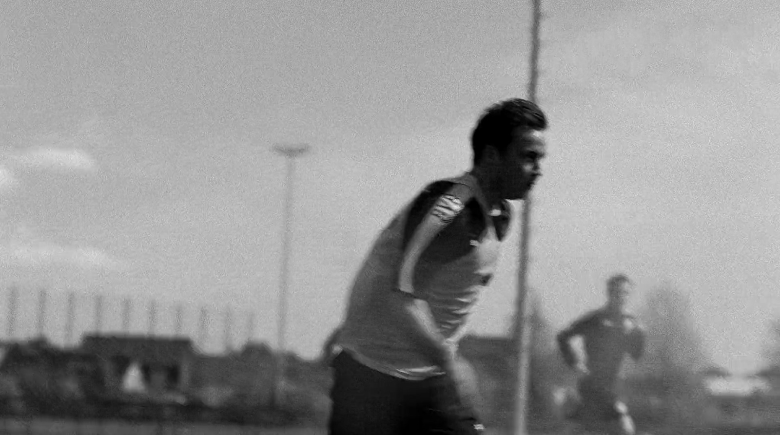 a black and white photo of two men playing soccer