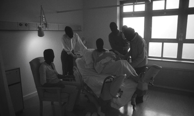 a group of people standing around a hospital bed