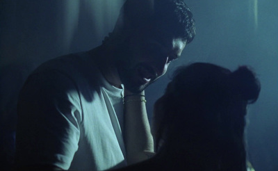 a man standing next to a woman in a dark room