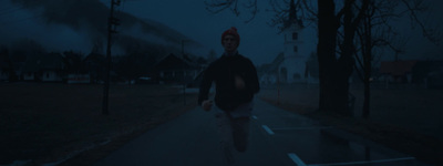 a man walking down a street at night