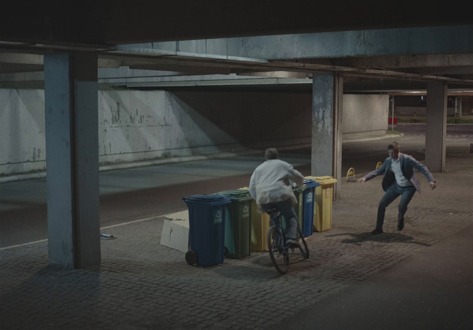 a man riding a bike next to a pile of trash