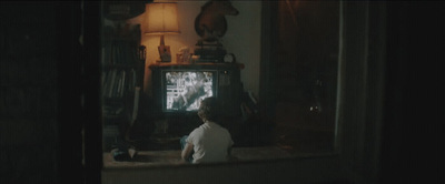 a little boy sitting in front of a tv