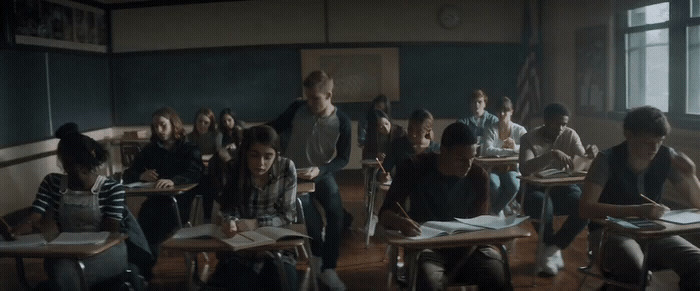 a group of people sitting at desks in a classroom