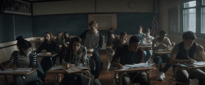 a group of people sitting at desks in a classroom