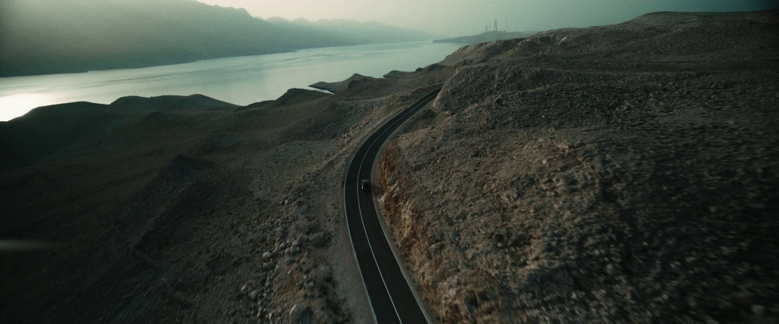 an aerial view of a winding road in the mountains