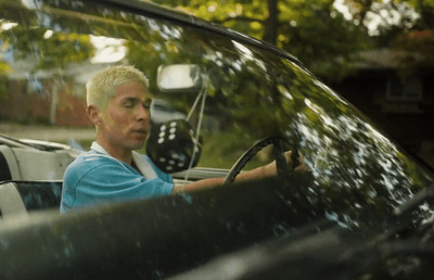 a man driving a car in the rain