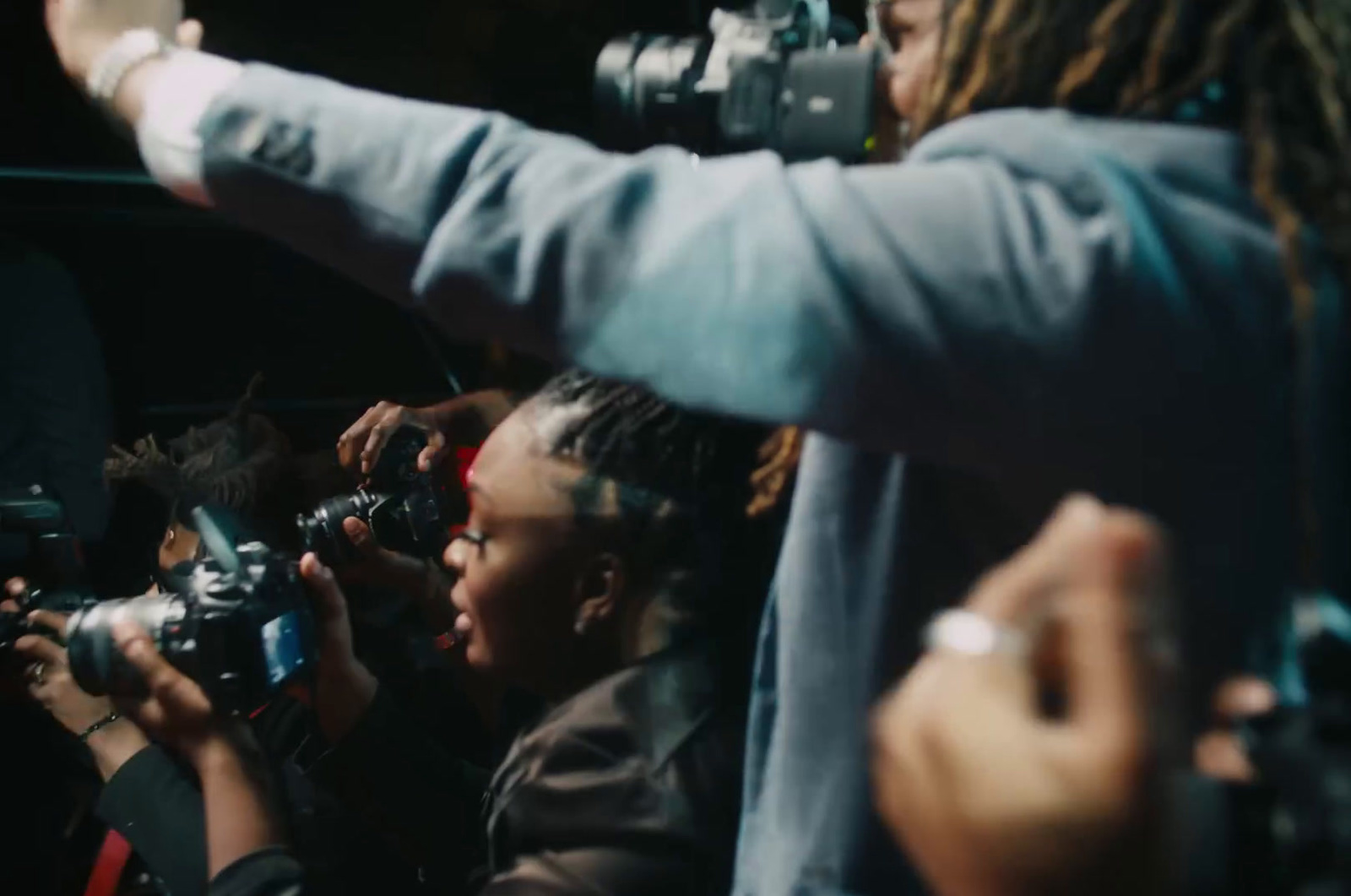 a group of people standing around each other taking pictures